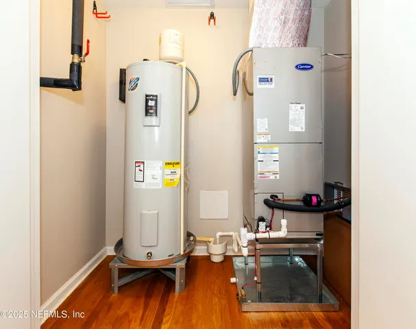 a front view of a brick house with a yard and potted plants