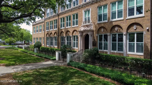 a view of a brick building next to a yard