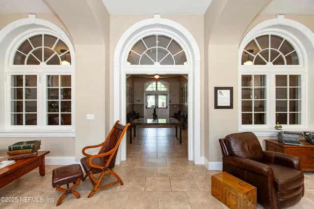 a living room with furniture a chandelier and a rug