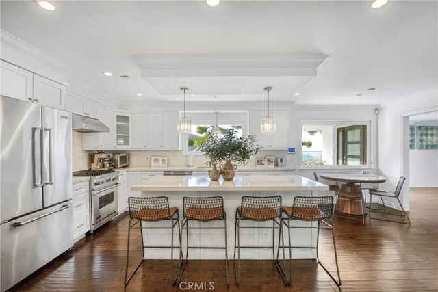 a kitchen with kitchen island a stove a table and chairs in it