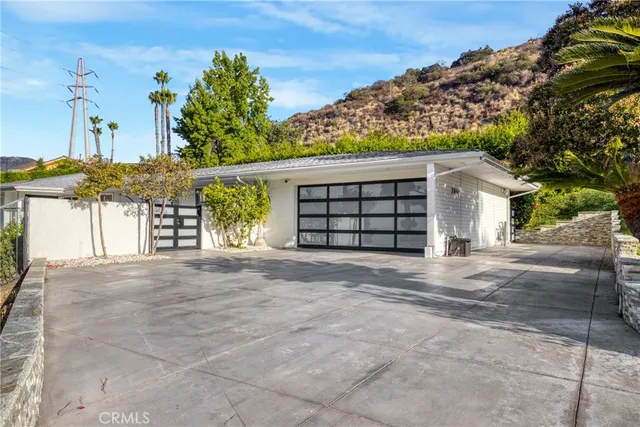 a view of a house with a yard and potted plants