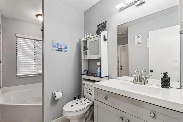a bathroom with a granite countertop sink a toilet and a mirror