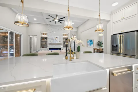 a kitchen with stainless steel appliances granite countertop a stove a sink and white cabinets
