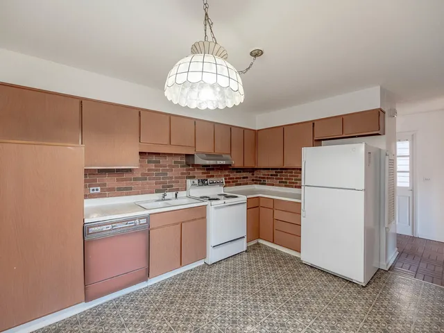 a kitchen with kitchen island white cabinets and white appliances