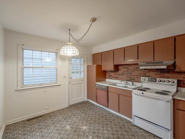 a kitchen with a stove a sink and cabinets