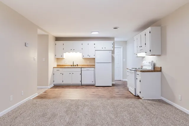 a kitchen with white cabinets and refrigerator