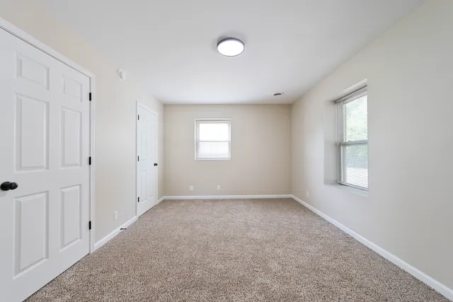 an empty room with windows and closet