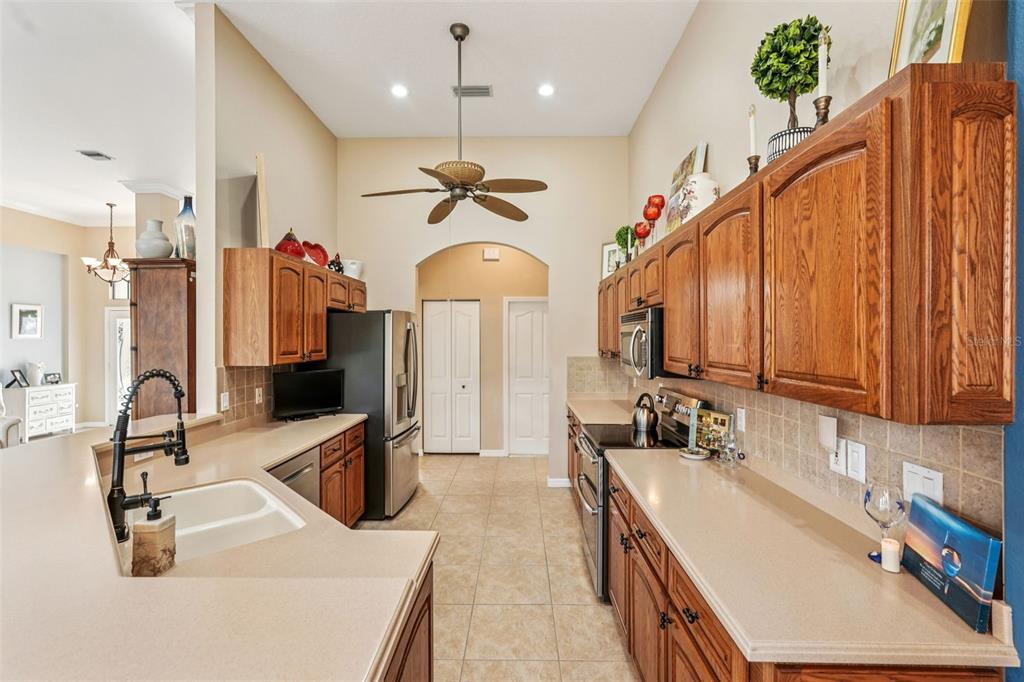 626 May Apple Way Venice, FL 34293 - Photo 11 of 60 a kitchen with stainless steel appliances a sink stove and cabinets