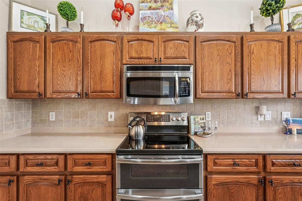 626 May Apple Way Venice, FL 34293 - Photo 12 of 60 a kitchen with stainless steel appliances granite countertop a stove top oven microwave and cabinets