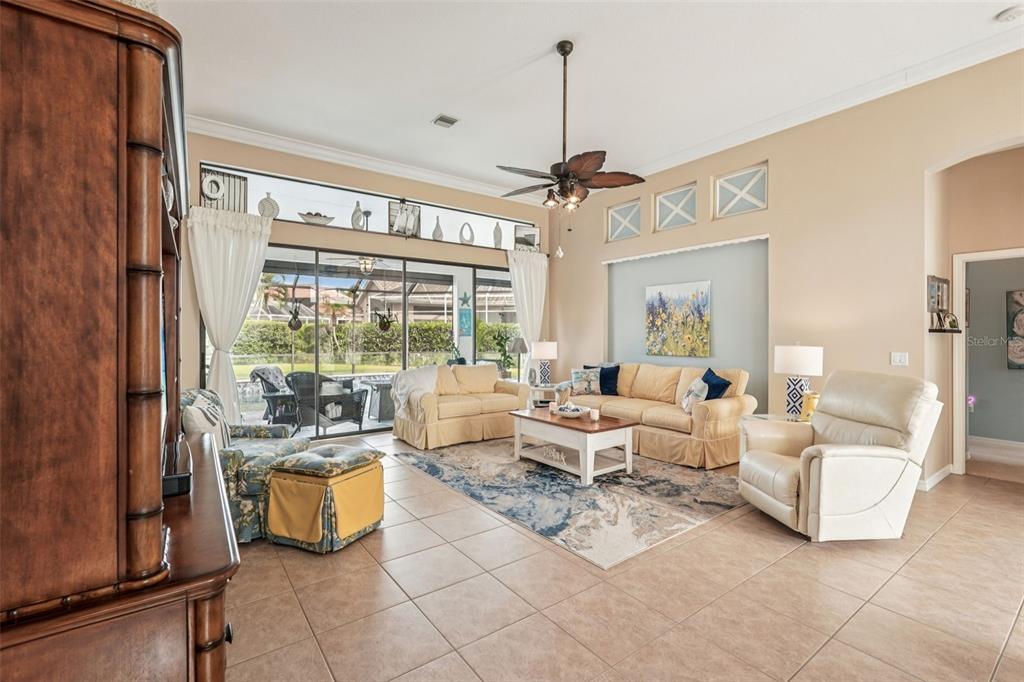 626 May Apple Way Venice, FL 34293 - Photo 18 of 60 a living room with furniture a large window and a chandelier