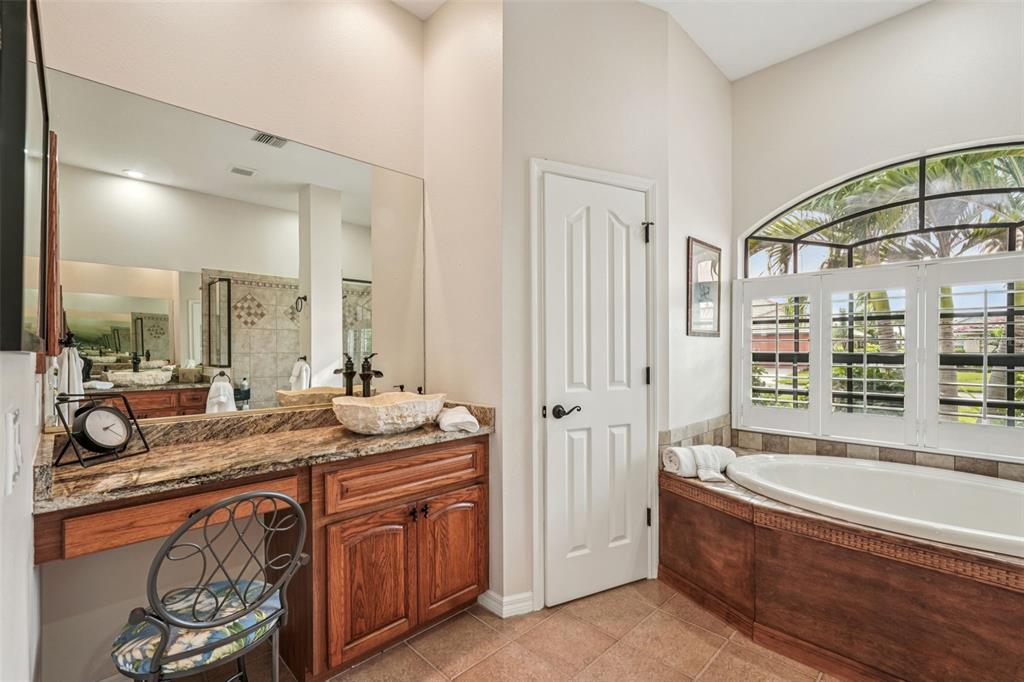626 May Apple Way Venice, FL 34293 - Photo 24 of 60 a spacious bathroom with a granite countertop tub sink and mirror