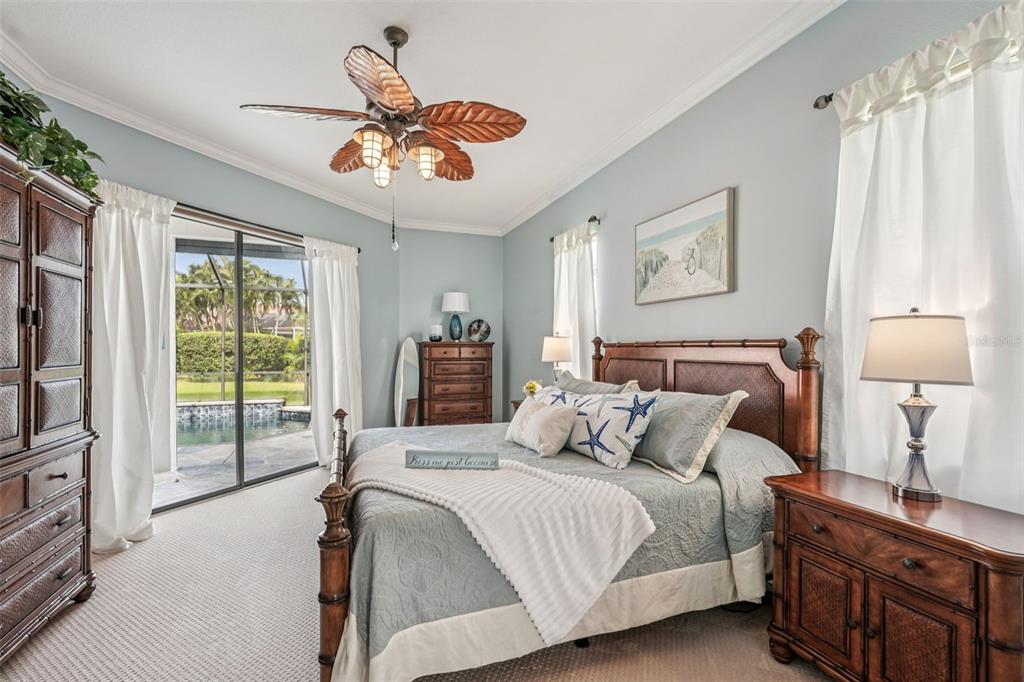626 May Apple Way Venice, FL 34293 - Photo 6 of 60 a bedroom with a balcony a bed and a chandelier