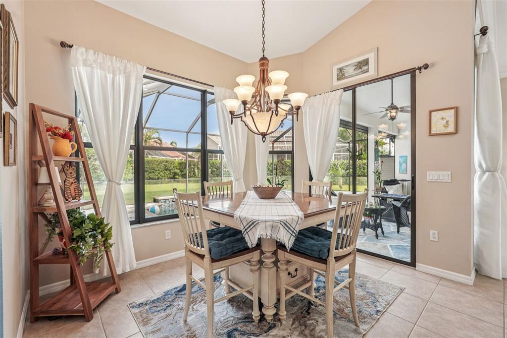 626 May Apple Way Venice, FL 34293 - Photo 9 of 60 a dining room with furniture potted plants and wooden floor