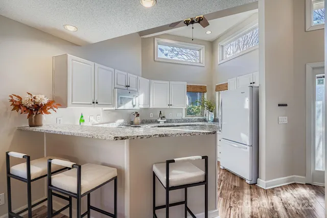 a kitchen with stainless steel appliances granite countertop a refrigerator and a stove top oven