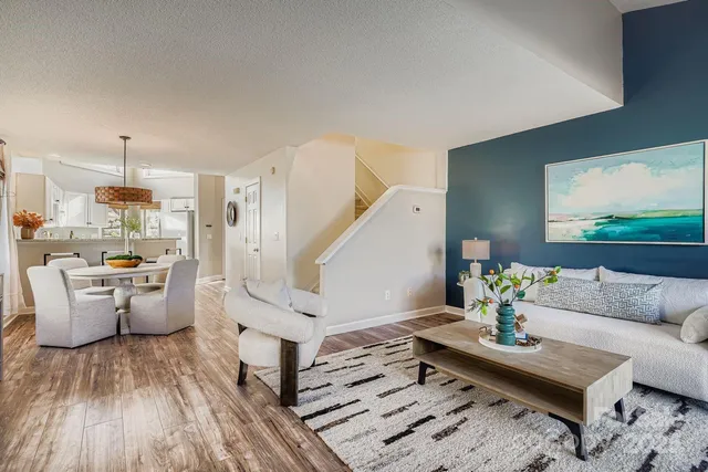 a living room with furniture and a wooden floor