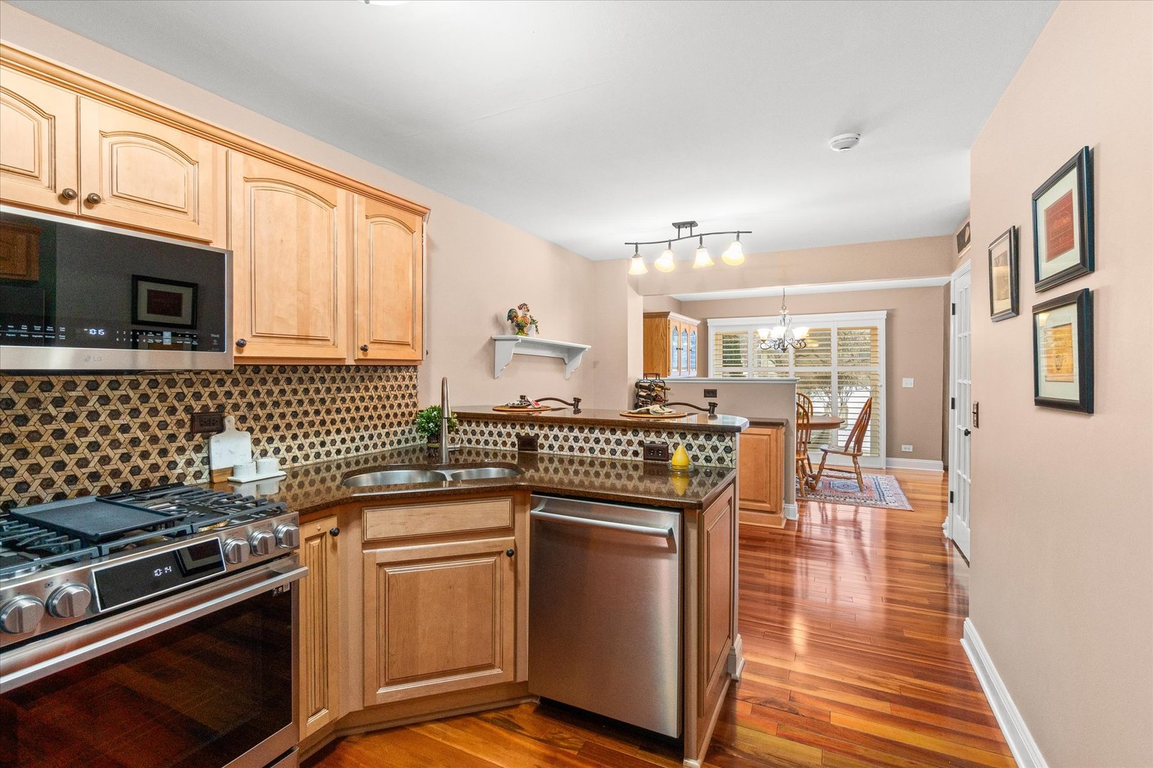 3819 Capri Court Naperville, IL 60564 - Photo 11 of 37 a kitchen with stainless steel appliances granite countertop a stove a sink dishwasher a microwave oven and a dining table with wooden floor