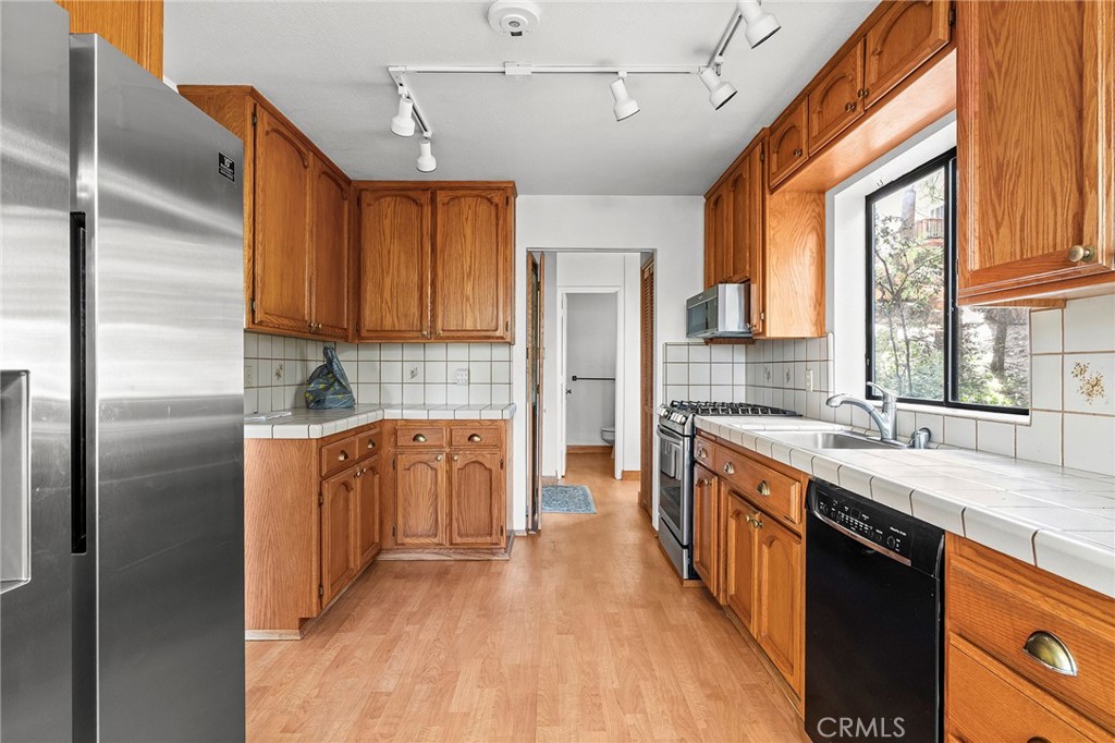 14243 Wycliff Way Magalia, CA 95954 - Photo 16 of 65 a kitchen with stainless steel appliances granite countertop a refrigerator a sink dishwasher a stove and white countertops with wooden floor