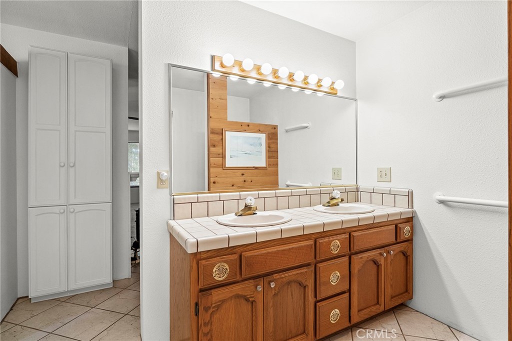 14243 Wycliff Way Magalia, CA 95954 - Photo 27 of 65 a bathroom with a double vanity sink and mirror