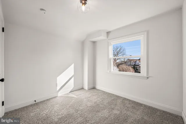 an empty room with windows and cabinet
