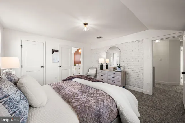 a bedroom with a large bed and a dresser