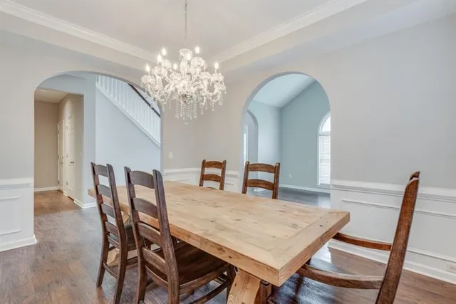 a kitchen with granite countertop a refrigerator a stove a sink dishwasher and white cabinets with wooden floor