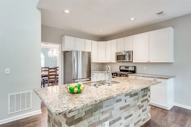 a kitchen with stainless steel appliances granite countertop a refrigerator sink and stove