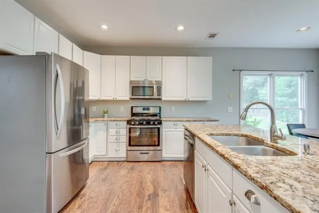 a kitchen with a sink cabinets and wooden floor