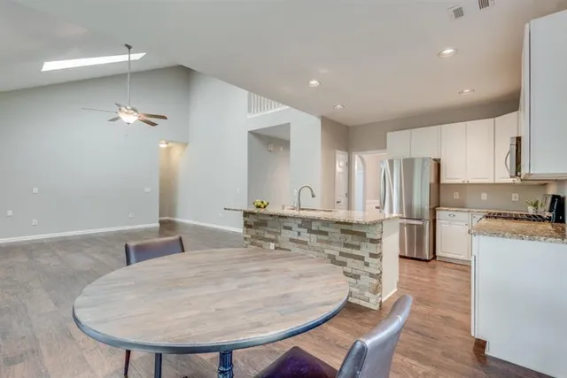an empty room with wooden floor fireplace and windows