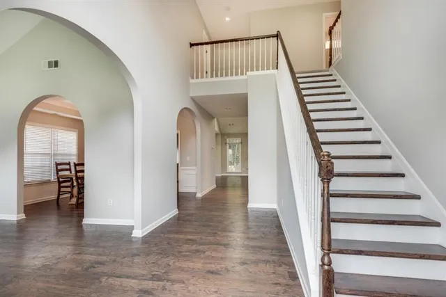 a view of a livingroom with wooden floor and stairs