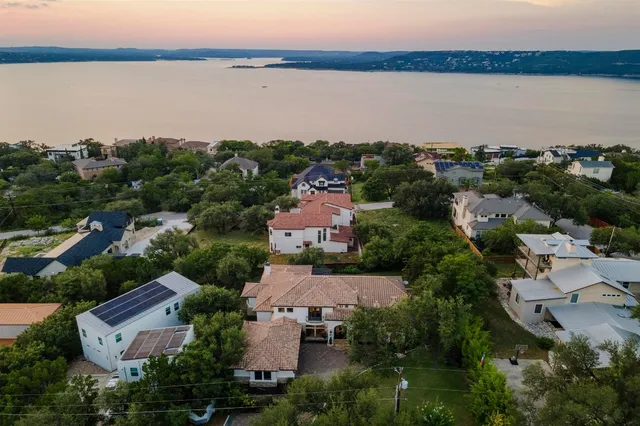 an aerial view of a house with a yard and lake view