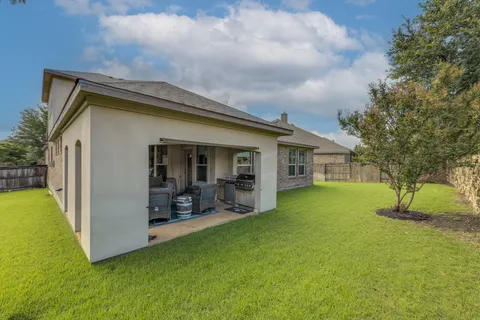 a view of a house with a yard patio and fire pit