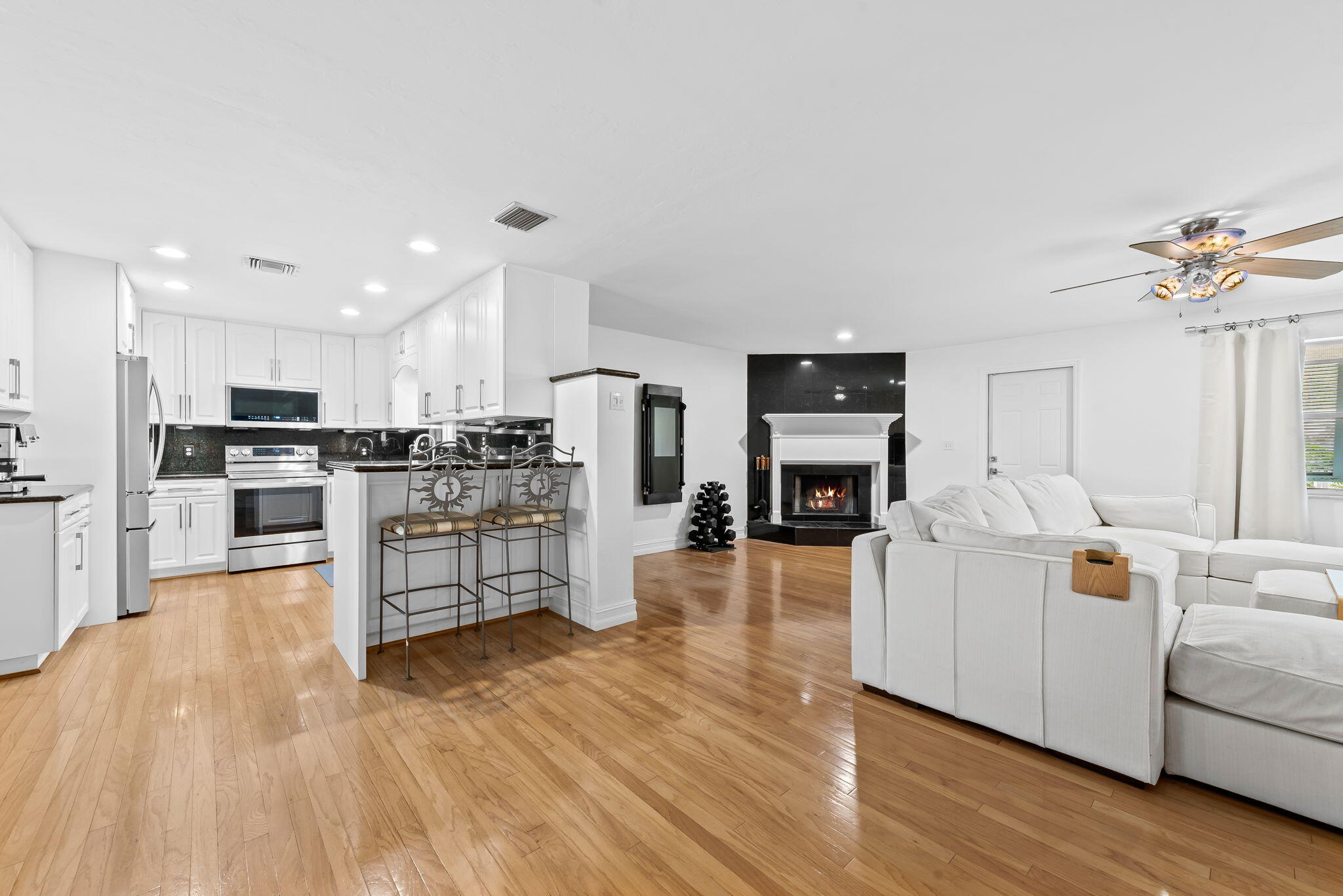 27 Northeast 16th Avenue Pompano Beach, FL 33060 - Photo 3 of 21 a living room with stainless steel appliances kitchen island wooden floors and white cabinets