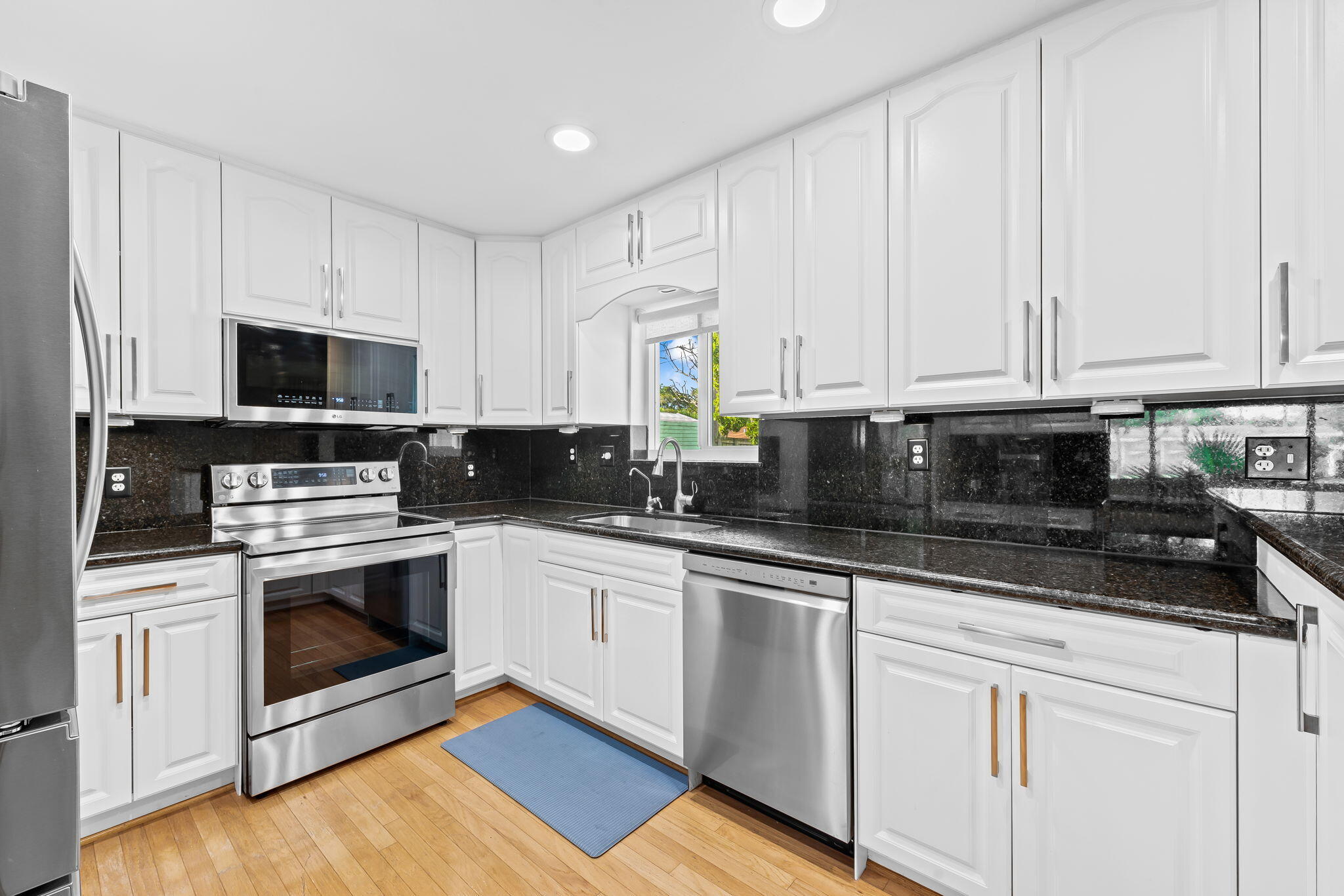 27 Northeast 16th Avenue Pompano Beach, FL 33060 - Photo 5 of 21 a kitchen with granite countertop white cabinets and stainless steel appliances