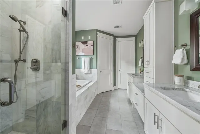 a bathroom with a granite countertop sink a mirror and a bathtub