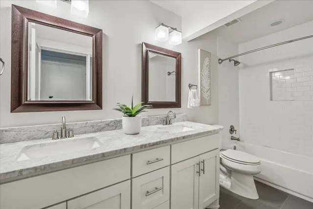 a bathroom with a granite countertop sink a toilet and a mirror