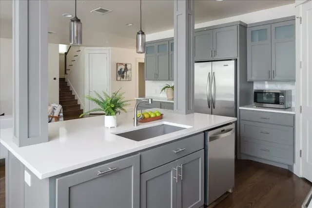 a kitchen with stainless steel appliances a sink a refrigerator a counter space and stainless steel appliances