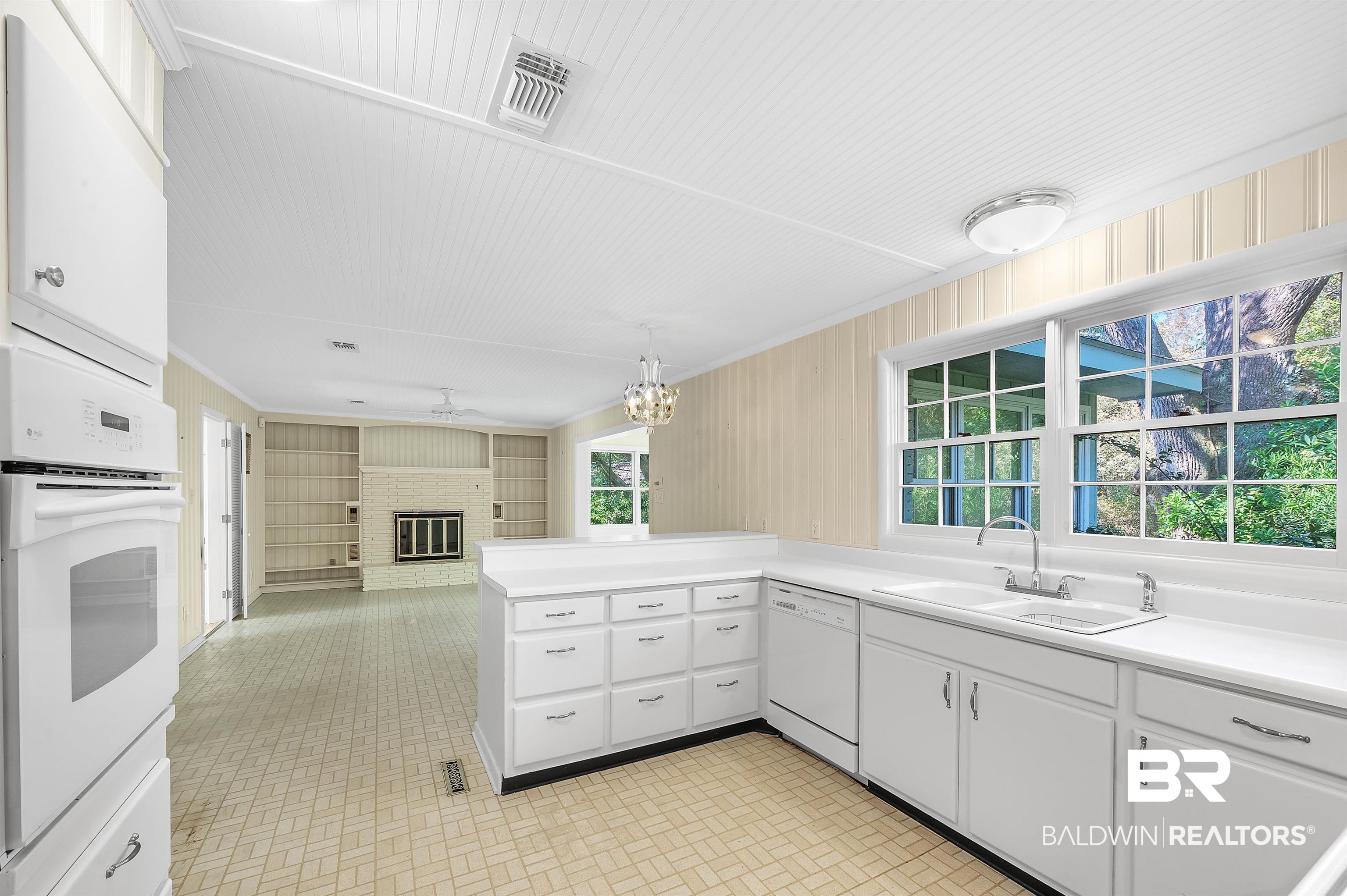 14375 Oak Street Magnolia Springs, AL 36555 - Photo 11 of 20 Kitchen with a brick fireplace, sink, white cabinets, and white appliances