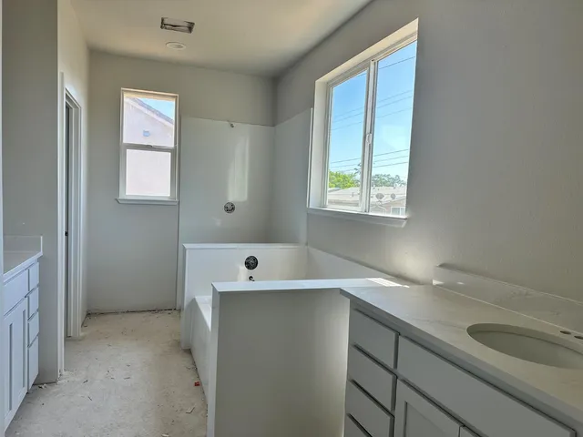 a room with a window sink and cabinets