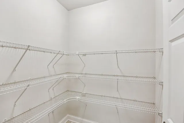 a view of a livingroom with a chandelier fan and windows