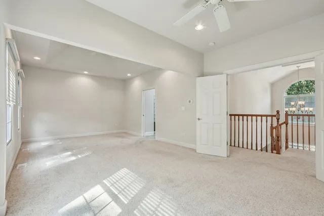 an empty room with windows and ceiling fan view