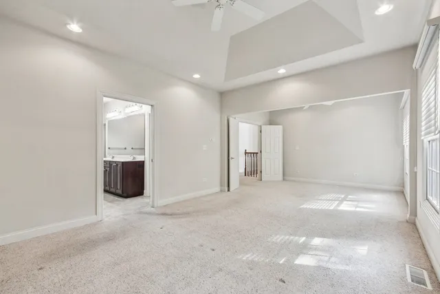 a view of an empty room and chandelier fan