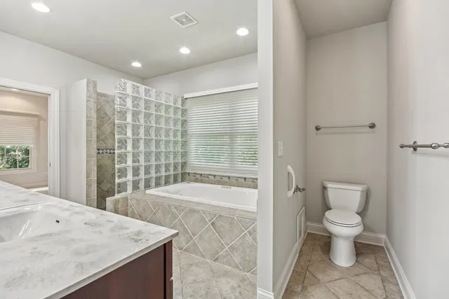 a white toilet sitting next to a bath tub