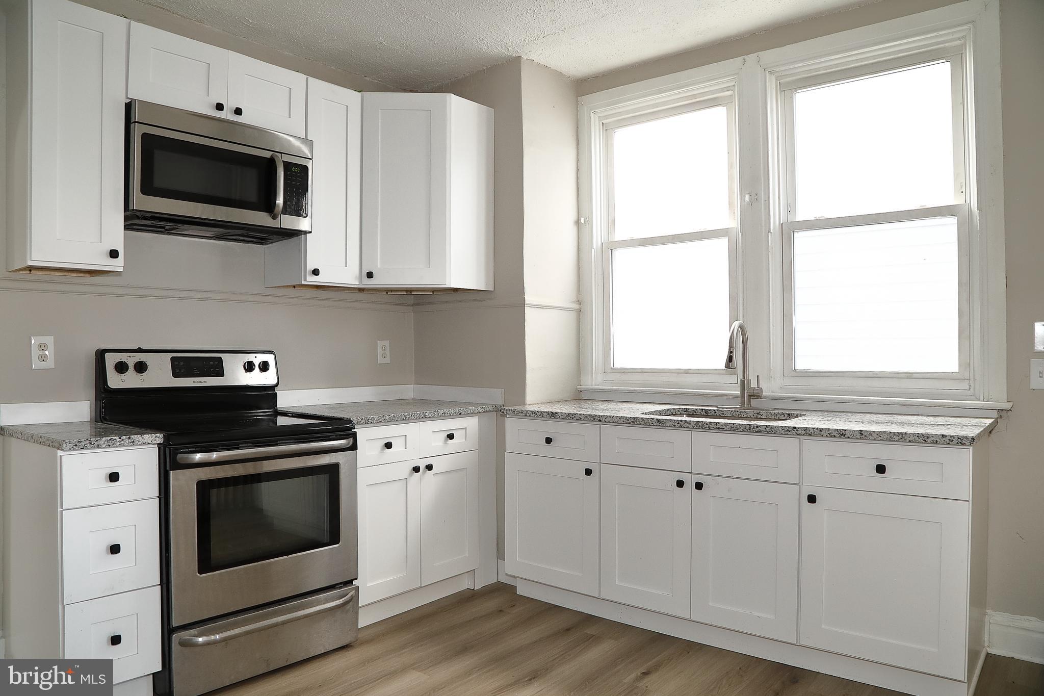 875 East Prospect Street York, PA 17403 - Photo 10 of 21 a kitchen with granite countertop white cabinets appliances and a window