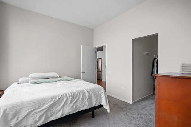 a bedroom with a bed and a refrigerator