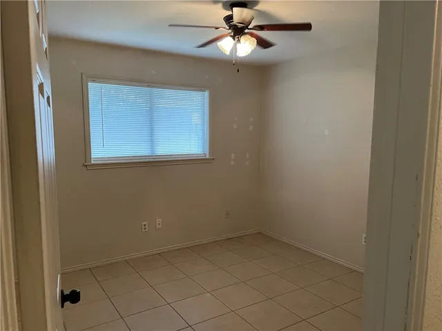 an empty room with a chandelier fan