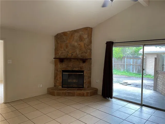 a living room with a fireplace and a floor to ceiling window