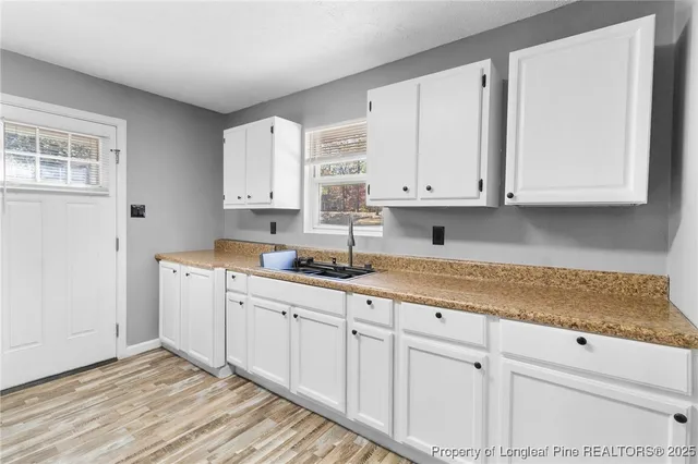 a kitchen with granite countertop white cabinets and sink