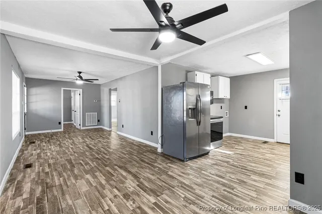 a view of a livingroom with kitchen and stainless steel appliances