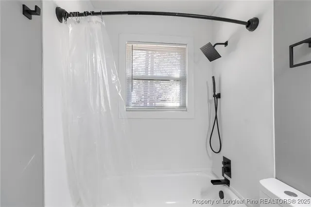 a bathroom with a shower and a window