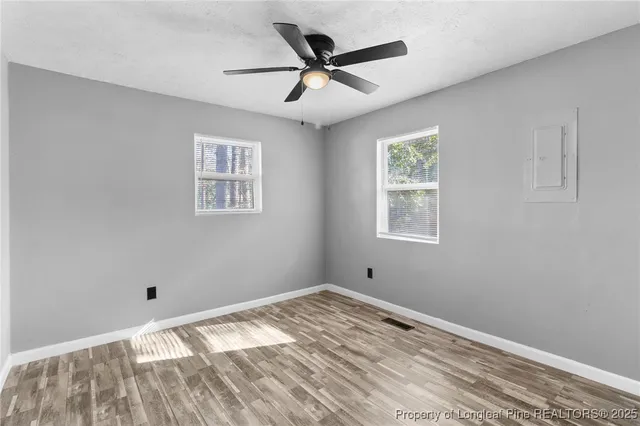 a view of empty room with wooden floor
